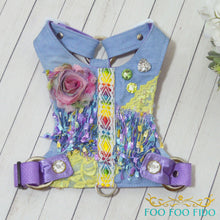 Decorative dog harness with colorful patterns and embellishments on a wooden surface, branded 'Foo Foo Fido'.